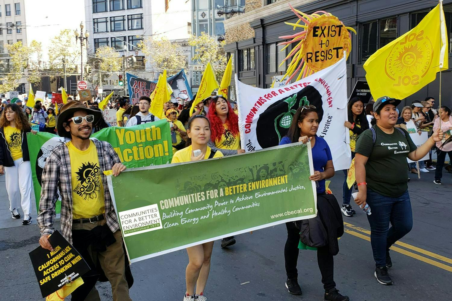 people marching and holding a sign in a rally for Communities for a Better Environment